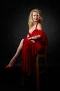 Attractive middle age woman in red evening dress with fluffy feather boa Royalty Free Stock Photo