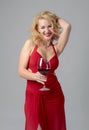 Attractive middle age woman in red evening dress with glass of red wine Royalty Free Stock Photo