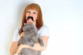 Mature woman having fun with a fake moustache and embracing pet.