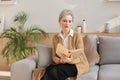 Attractive middle aged woman enjoying reading a book sitting on the sofa in her living room smiling while she reading Royalty Free Stock Photo