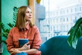 Attractive middle aged woman enjoying reading book, sitting on sofa in her Royalty Free Stock Photo