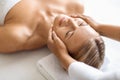 Attractive middle aged woman having revitalizing face lifting massage at spa salon Royalty Free Stock Photo