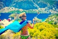 Attractive middle aged woman making selfie photo with selfie stick in hot summer day on Kamelya Island