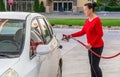 Attractive Middle-aged Woman Pumping Gasoline