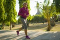 Attractive middle aged woman running happy at city park . beautiful and sporty lady on her 40s exercising doing jogging workout on Royalty Free Stock Photo