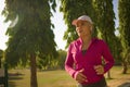 Attractive middle aged woman running happy at city park . beautiful and sporty lady on her 40s exercising doing jogging workout on Royalty Free Stock Photo