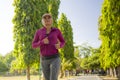 Attractive middle aged woman running happy at city park . beautiful and sporty lady on her 40s exercising doing jogging workout on Royalty Free Stock Photo