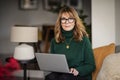 Casual woman sitting at home and using laptop for work Royalty Free Stock Photo