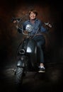 Attractive middle aged woman sitting on a scooter
