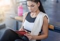 Attractive millennial girl writing her workout plan in notebook at fitness club Royalty Free Stock Photo