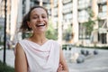 Attractive mixed race Hispanic, African American woman smiling with toothy smile standing on the urban buildings background. Royalty Free Stock Photo