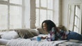 Attractive mixed race teenage girl lauging using laptop for sharing social media lying in bed at home Royalty Free Stock Photo