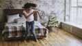 Attractive mixed race young joyful woman have fun dancing near bed at home Royalty Free Stock Photo