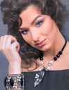 Close-up of Young Caucasian Woman with Jewelry. She Wears a Necklace With White and Black Pearls and a Statement Bracelet, on Grey Royalty Free Stock Photo