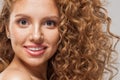 Attractive model with wavy hairstyle, beautiful face close up. Pretty young woman with curly hair, clear skin and natural makeup Royalty Free Stock Photo