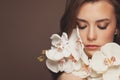 Attractive model woman with healthy clear skin and spring orchid flowers. Facial treatment and skin care concept Royalty Free Stock Photo