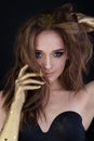 Attractive model woman with long brown hair, smoky eyes makeup and golden hands Royalty Free Stock Photo