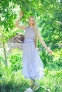 Attractive modest young girl with blond hair and natural make-up in purple dress outdoors, tenderness and softness on nature