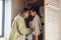 An attractive mom and her cute baby are doing household chores. A young woman and her daughter load a washing machine