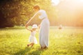 Attractive mother dancing with her daughter on the lawn