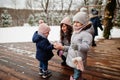 Attractive mother with her two pretty daughters in winter day. Mom puts on a baby glove Royalty Free Stock Photo