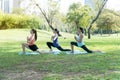 Mother and two daughter relax by doing exercise practicing yoga in the park. Healthy lifestyle concept Royalty Free Stock Photo