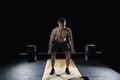 Attractive muscular bodybuilder doing deadlifts in modern fitness center