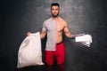 attractive muscular caucasian man holding a pillow and some papers, promoting a healthy lifestyle and fitness training