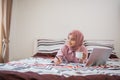 attractive Muslim woman in hijab writing while lying down