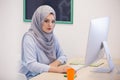 Attractive Muslim young woman working in office on computer