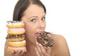 Attractive Natural Happy Young Woman Eating a Pile of Iced Donuts