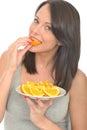 Attractive Natural Happy Young Woman Eating a Plate of Ripe Fresh Orange Segments