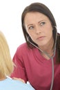 Attractive Natural Young Professional Female Doctor Listening Carefully With A Stethoscope Royalty Free Stock Photo