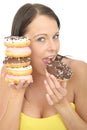 Attractive Natural Young Woman Eating a Pile of Iced Donuts