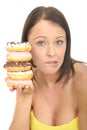 Attractive Natural Young Woman Holding a Pile of Iced Donuts with Guilty Facial Expression Royalty Free Stock Photo