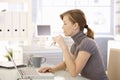 Attractive office worker sitting at desk Royalty Free Stock Photo