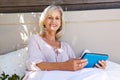 Attractive older woman sitting outside with digital tablet Royalty Free Stock Photo