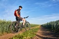 Attractive one cyclist on mountainbike on path near green fields in the countryside in the summer season. Royalty Free Stock Photo