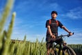 Attractive one cyclist on mountainbike on path near green fields in the countryside in the summer season. Royalty Free Stock Photo