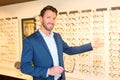 Attractive optician working in his glasses shop