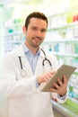 Attractive pharmacist using tablet at work