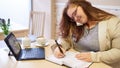 Attractive plus size business woman working in bright coffee shop