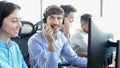 Attractive positive young businesspeople and colleagues in a call center office