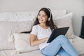 Preteen girl wear headphones using modern digital tablet at home Royalty Free Stock Photo