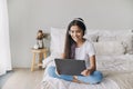 Preteen girl wear headphones using modern digital tablet at home Royalty Free Stock Photo