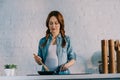 attractive pregnant woman cooking at electric stove
