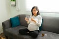 Attractive pregnant woman taking pain pills with water Royalty Free Stock Photo