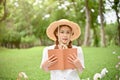 Attractive young Asian female standing in a beautiful green garden wearing a straw hat Royalty Free Stock Photo