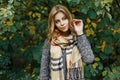 Attractive pretty young woman with blue eyes in a vitage scarf in an elegant coat in the park Royalty Free Stock Photo