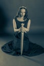 Attractive princess girl kneeling with a sword Royalty Free Stock Photo